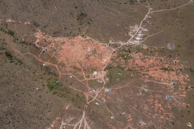 Overhead drone shot of an illegal mining camp at the base of the Serra do Atola mountain