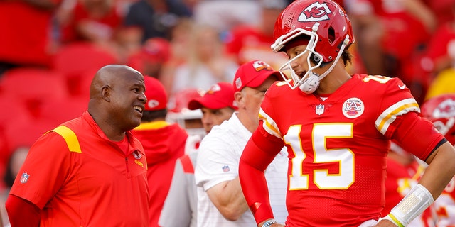 Kansas City Chiefs offensive coordinator Eric Bieniemy speaks with Patrick Mahomes #15 of the Kansas City Chiefs during pregame warmups prior to the game against the Los Angeles Chargers at Arrowhead Stadium on Sept. 15, 2022 in Kansas City, Missouri.