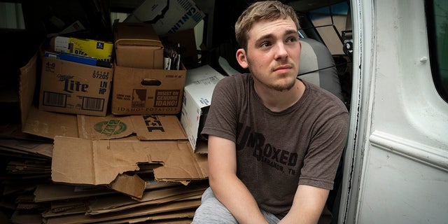 UnBoxed owner Ashton Gilbert rests in his van filled with cardboard boxes.