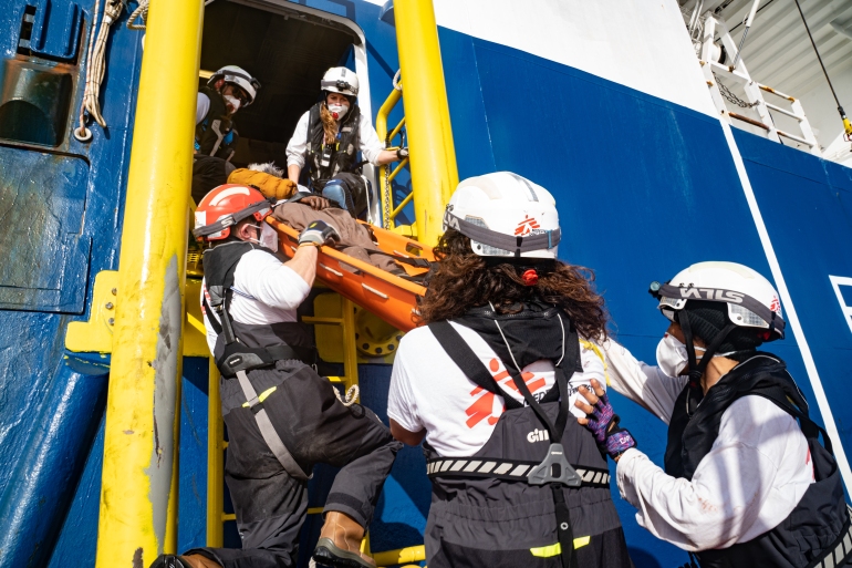 Mediterranean Sea near to Libya, 23 April 2022, Nejma Banks (far right) and other members of the MSF team lift Sadia*, in the stretcher, onto the deck of the Geo Barents. 