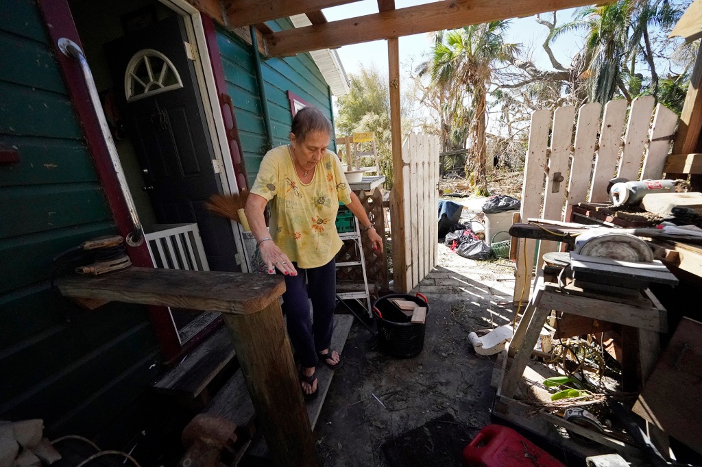 Kathleen Russell and her husband walk outside her home that was heavily damaged by flooding on Pine Island.