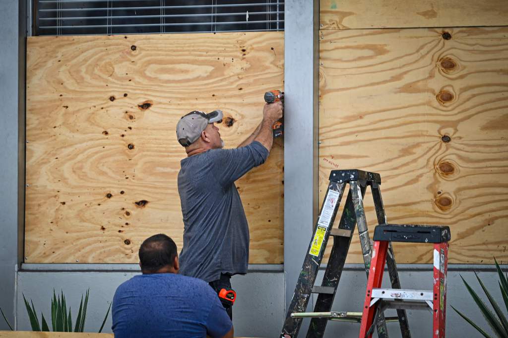People board up a window in Tampa, Florida on Tuesday as the city prepares for the landfall of Hurricane Idalia