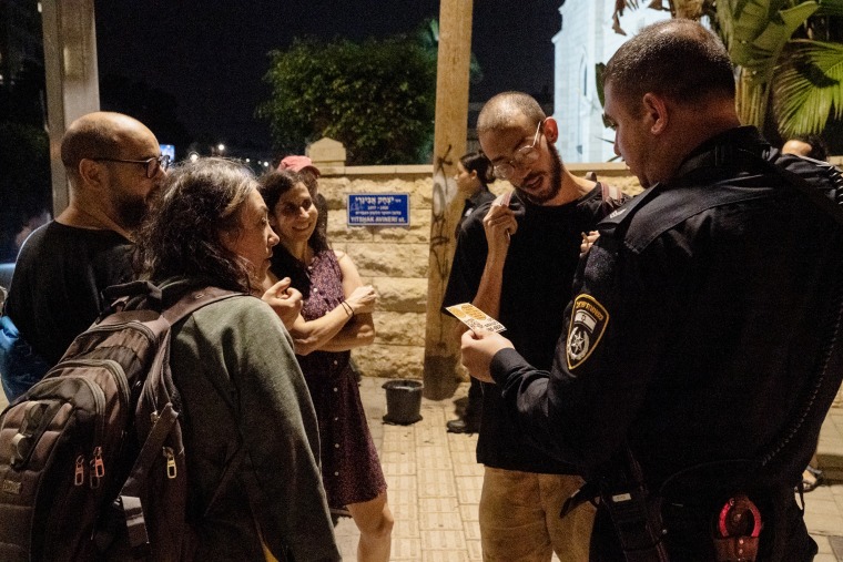Members of the Arab-Jewish Partnership Guard in Tel-Aviv-Jaffa are stopped by police as they put up anti-war posters in Jaffa, Israel.